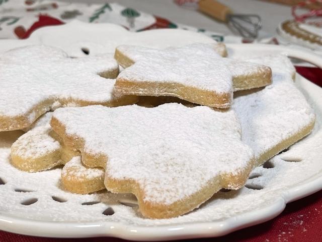 Paste frolle di Santa Lucia a forma di stella e di albero di Natale decorate con zucchero a velo
