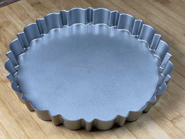 tortiera antiaderente con il fondo removibile e il bordo decorato