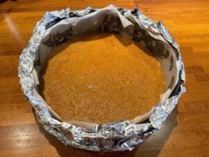 Base della cheesecake vegana pressata nella tortiera prima della cottura