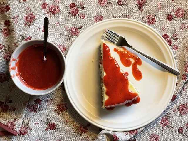 Vista dall’alto di una fetta di cheesecake vegana con salsa alle fragole