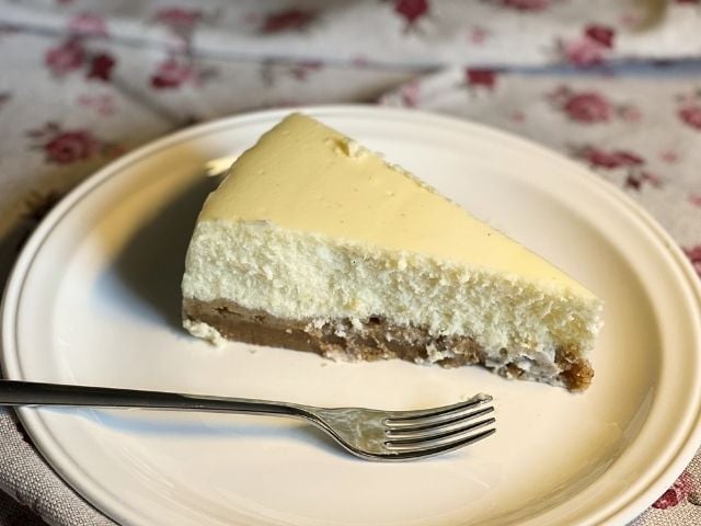 Fetta di cheesecake vegana bianca senza salsa che mostra la consistenza cremosa
