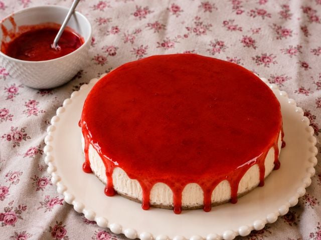 New York cheesecake vegana cotta al forno con salsa alle fragole servita su piatto bianco
