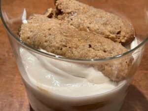 Preparazione del tiramisù vegano con savoiardi inzuppati nel caffè
