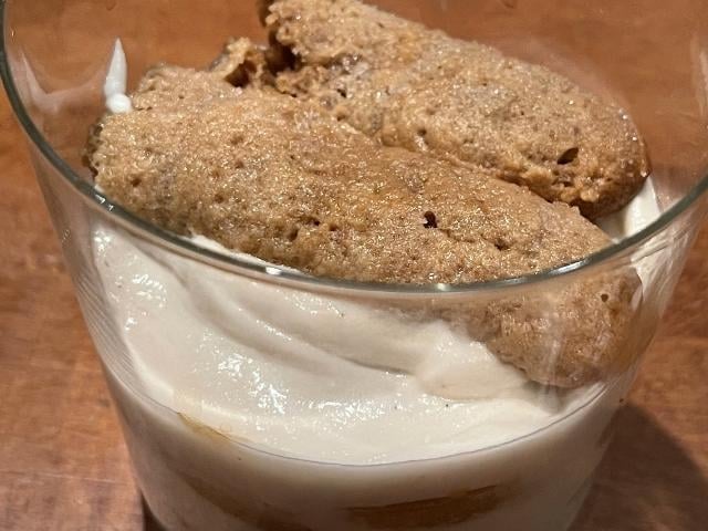Preparazione del tiramisù vegano con savoiardi inzuppati nel caffè