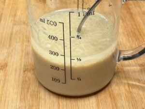 Ingredienti liquidi mescolati per la torta di mele vegana