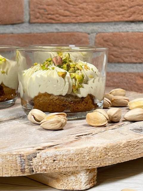 Tiramisù al pistacchio senza uova su vassoio con pistacchi