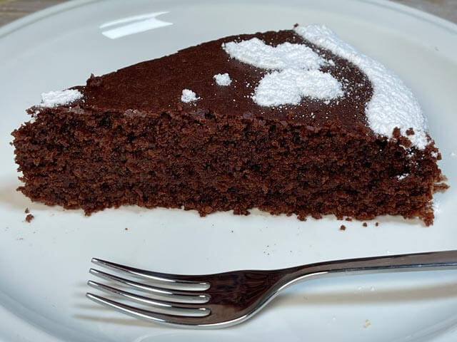 fetta di torta caprese vegana umida e friabile