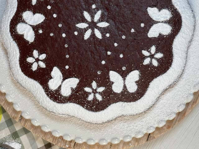 torta caprese senza uova e burro decorata con zucchero a velo