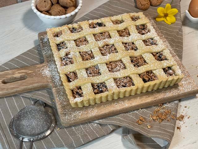 crostata con amaretti e marmellata dorata pronta da porzionare