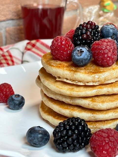 torre di pancake vegani morbidi con lamponi, mirtilli e more