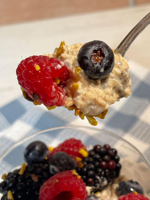 overnight oats con mirtilli e lamponi al cucchiaio