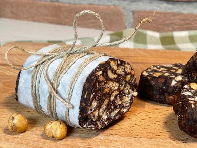 salame di cioccolato senza burro e uova legato con lo spago sul tagliere