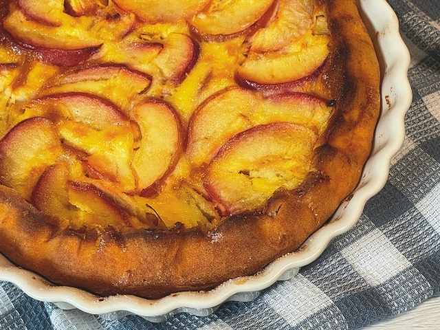 clafoutis alle pesche cotta alla perfezione nella tortiera a bordi alti