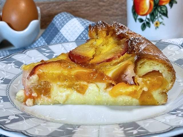 fetta di clafoutis di pesche cremosa e profumata