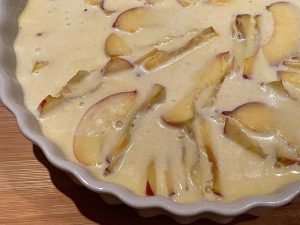 impasto del clafoutis di pesche versato nello stampo