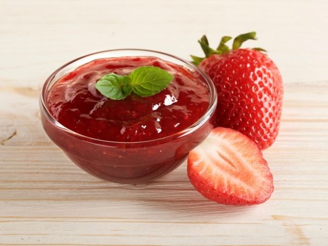 ciotolina di confettura di fragole fresche con due foglioline di menta