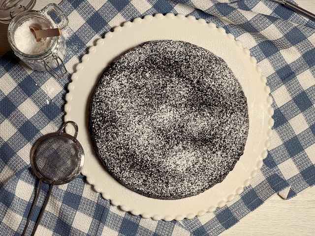 torta tenerina vegan sul piatto da portata bianco decorata con zucchero a velo