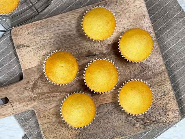 muffin senza latte perfettamente dorati a raffreddare sul tagliere di legno
