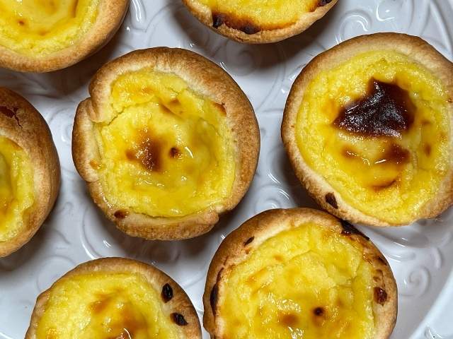 pastel de nata appena sfornati pronti per essere spolverati di cannella
