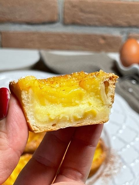 pastel de nata tagliato a metà che evidenzia il ripieno goloso di crema aromatizzata al limone