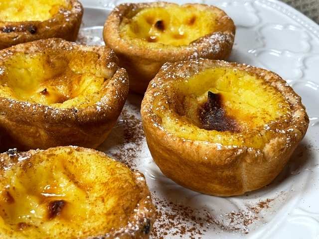 pastel de nata dorati spolverati di zucchero a velo e cannella