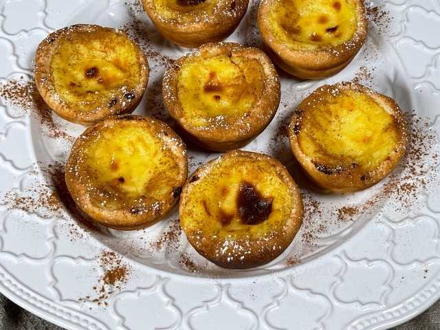 pastel de nata pronti per essere serviti con una leggera spolverata di cannella e zucchero a velo