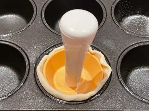 posizionamento di un dischetto di pasta sfoglia all'interno della cavità dello stampo