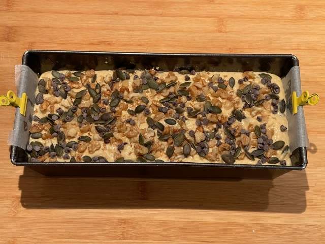 plumcake alla zucca e yogurt nello stampo decorato con frutta secca pronto da infornare