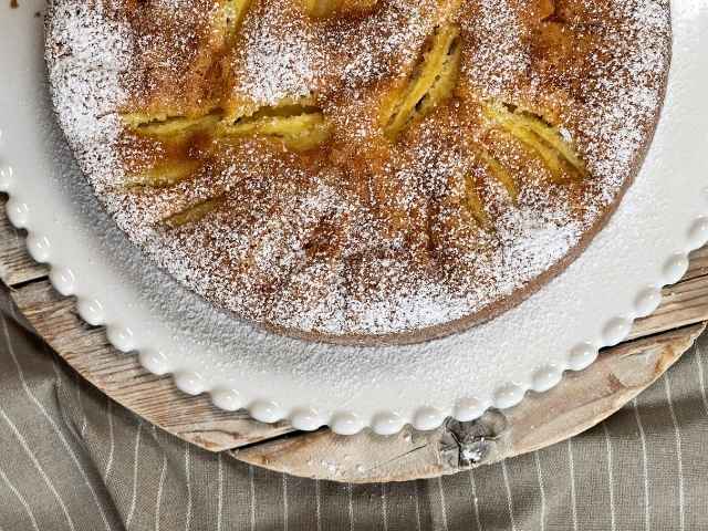 torta di mele gluten free spolverata di zucchero a velo sul piatto da portata