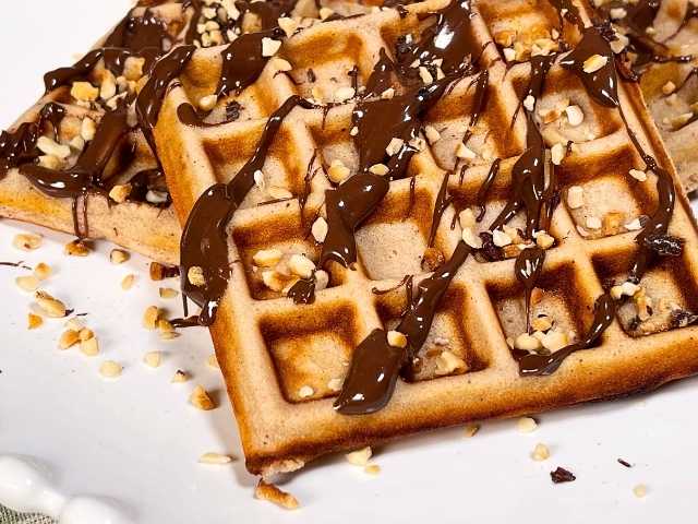 waffle senza glutine serviti con crema al cioccolato e granella di nocciole