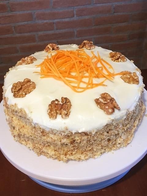 torta di carote americana decorata con noci spezzettate e gherigli