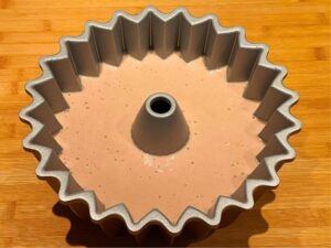 impasto del ciambellone senza uova e latte versato nello stampo pronto da infornare