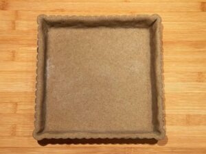 tortiera foderata di pasta frolla con farina di grano saraceno