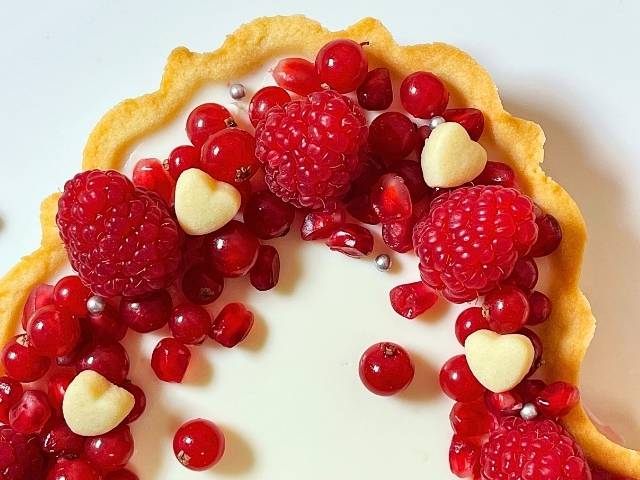 dettaglio della crostata di frutta a forma di cuore decorata con biscottini di pasta frolla