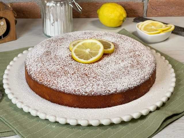 torta al limone senza glutine decorata con zucchero a velo e fette di limone