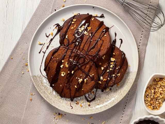 pancake al cacao serviti con cioccolato fuso e granella di nocciole