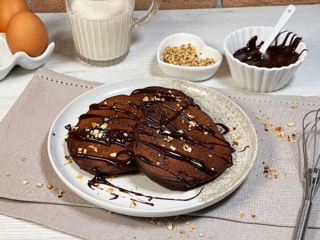 pancake al cacao decorati con granella di frutta secca e cioccolato fondente