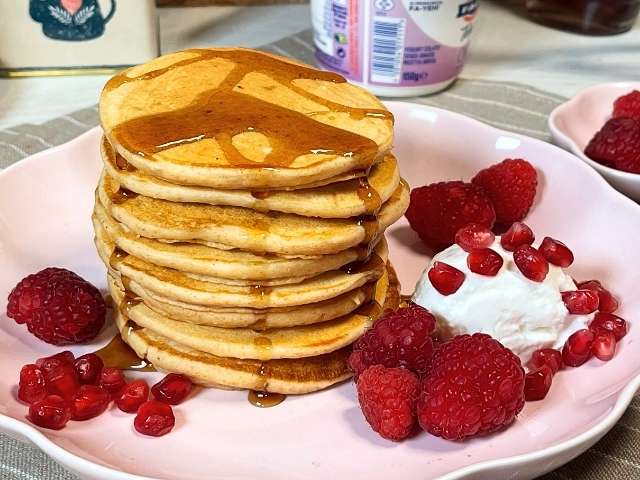 torre di pancakes con latte di soia serviti con frutta di stagione e sciroppo d'acero