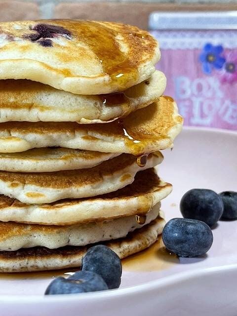 torre di pancake con mirtilli serviti con una colata di sciroppo d'acero