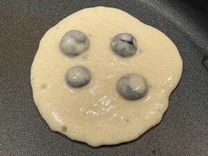 cottura del primo lato dei pancake con mirtilli