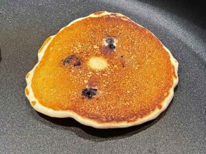 cottura del secondo lato dei pancake con mirtilli