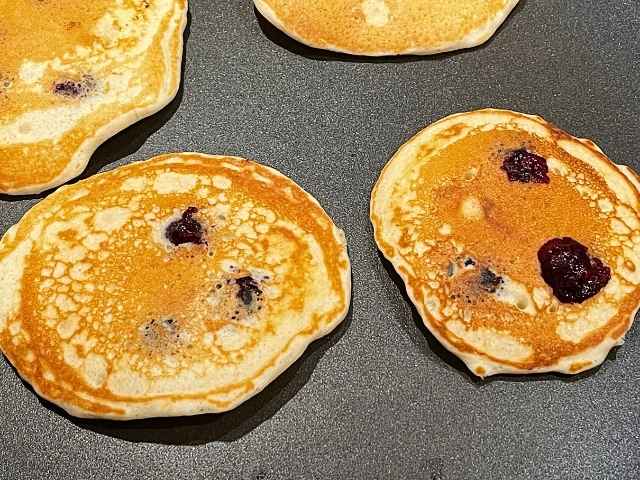 cottura dei pancake con mirtilli freschi aggiunti nella pastella