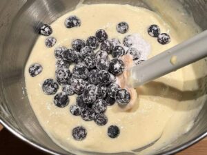 aggiunta dei mirtilli all'impasto della torta ai mirtilli e ricotta