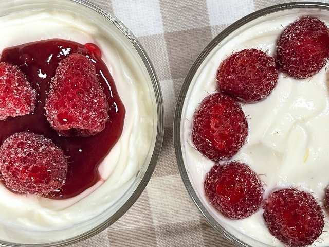 Due varianti di cheesecake allo yogurt senza gelatina decorate con lamponi