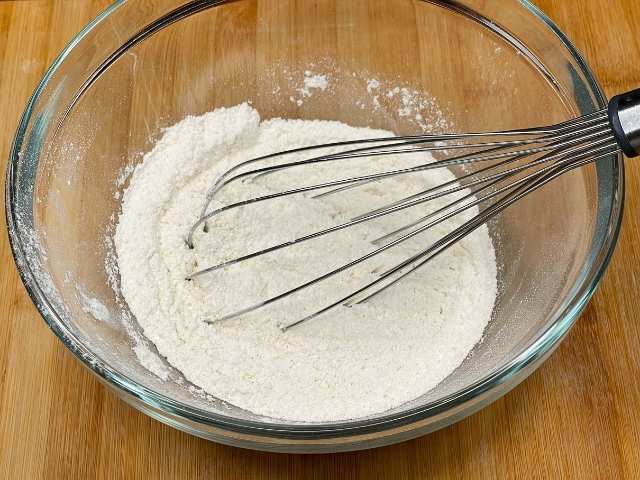 Farina 0 e lievito per dolci setacciati in una ciotola.