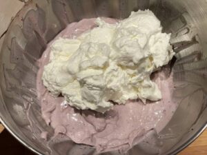 Panna fresca montata aggiunta alla crema della cheesecake con ricotta senza cottura