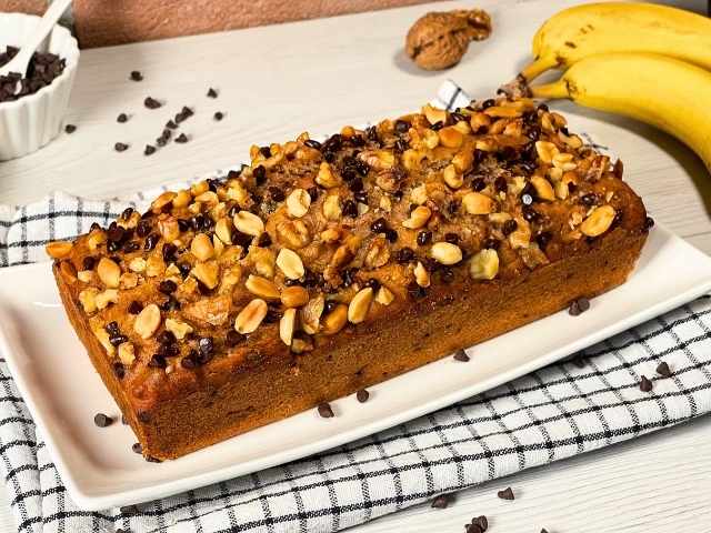 Banana bread vegano visto dall'alto con cioccolato, noci e arachidi salate