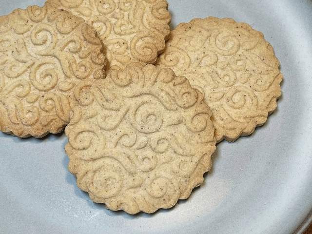 Biscotti cotti con farina di chufa senza glutine, rotondi e decorati con motivi a spirale.