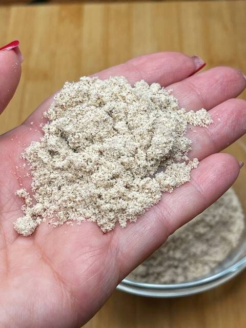 Farina di chufa sul palmo della mano per mostrarne la consistenza.