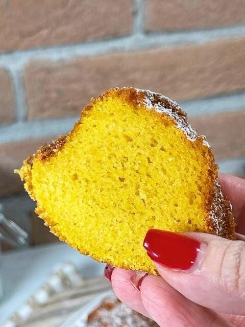 Fetta di ciambella di zucca senza glutine tenuta in mano per mostrare la mollica